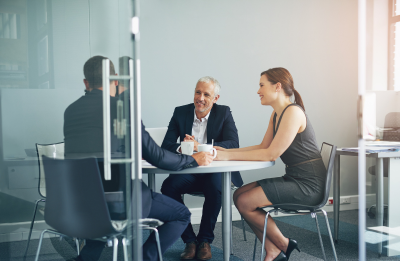 three people talking around a table