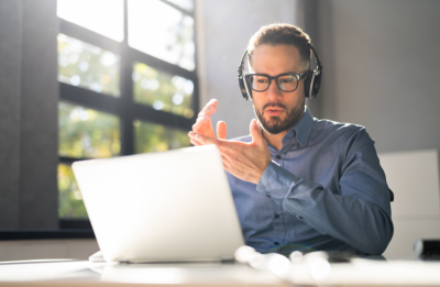 man at computer with headphones